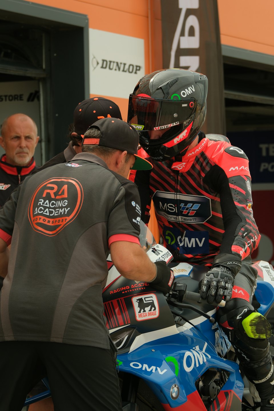 Un meccanico lavora su una moto da corsa ai box.